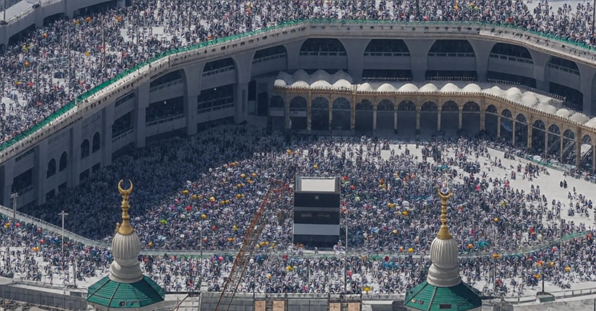 A vibrant scene from Hajj 2025 on June 5, at 08:53 PM PKT, showing a diverse group of pilgrims gathered on the plains of Arafah, listening to the Kutba through earpieces in 35 languages. Men and women in white Ihram garments stand under a golden sunset, with a large screen displaying translations in languages like Urdu and Swahili, while a banner with a peace dove flutters gently, symbolizing unity amidst the sacred pilgrimage.