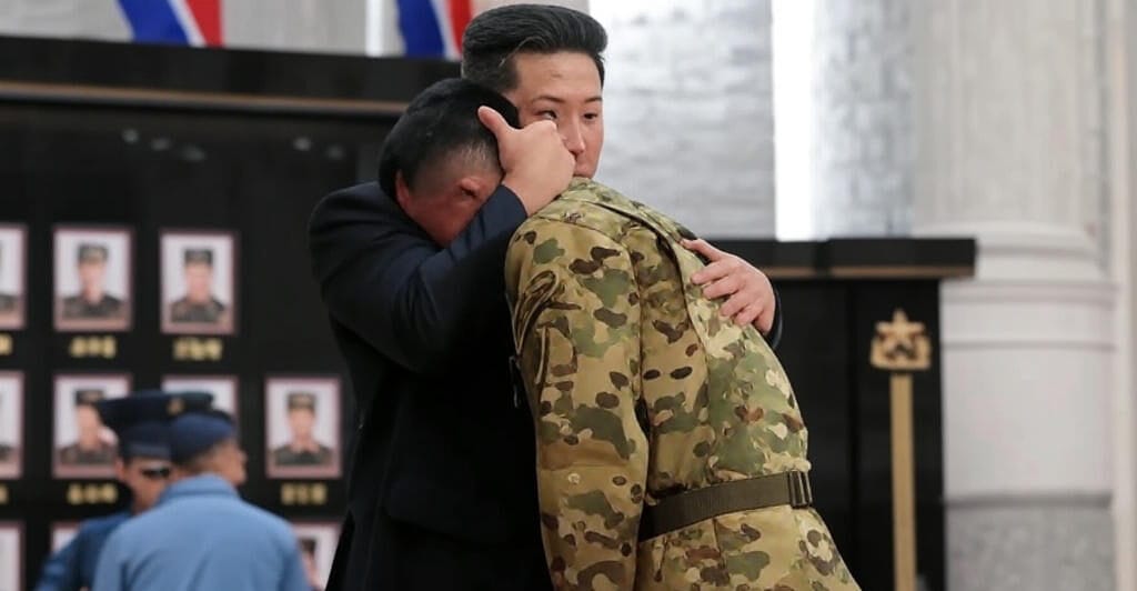 "Kim Jong-un embraces a soldier during a Pyongyang ceremony, with portraits of fallen troops displayed on the wall, honoring North Korean soldiers involved in the Russia-Ukraine conflict."
