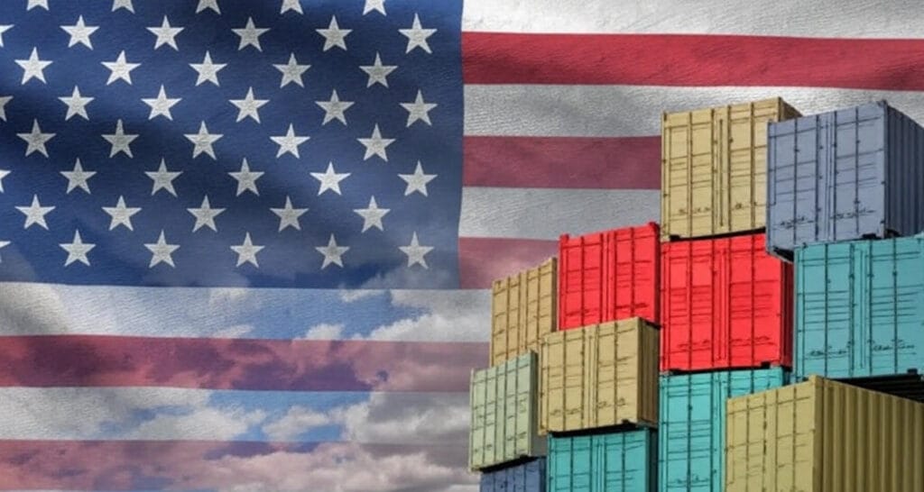 The image features a stylized representation of the American flag with its stars and stripes dominating the left side, set against a backdrop of a partly cloudy sky with warm tones. On the right side, a stack of colorful shipping containers in shades of red, orange, green, blue, and beige is prominently displayed, symbolizing trade and logistics. The composition blends national symbolism with elements of international commerce.