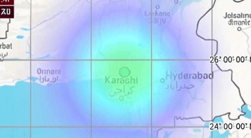 The image is a map highlighting a region in Pakistan, centered on Karachi, with a gradient overlay indicating a potential area of interest or impact, such as a weather pattern or event radius. The map includes surrounding cities such as Hyderabad, Larkana, and Ormara, with latitude lines marked at 24° 00' 00" N and 26° 00' 00" N. The gradient colors range from green at the center (Karachi) to blue and purple at the edges, suggesting a decreasing intensity or distance from the focal point. The map also features a grid overlay and place names in both English and Urdu script.