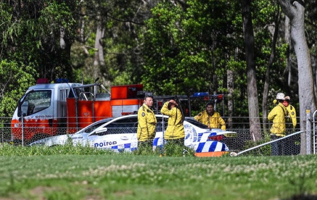 A dramatic depiction of the Sydney Plane Crash 2025 near Bankstown Airport, south of Sydney, Australia, featuring a light plane engulfed in flames with emergency response teams actively responding, captured at 08:53 PM PKT on October 11, 2025, as detailed in the newsflayer.com blog.